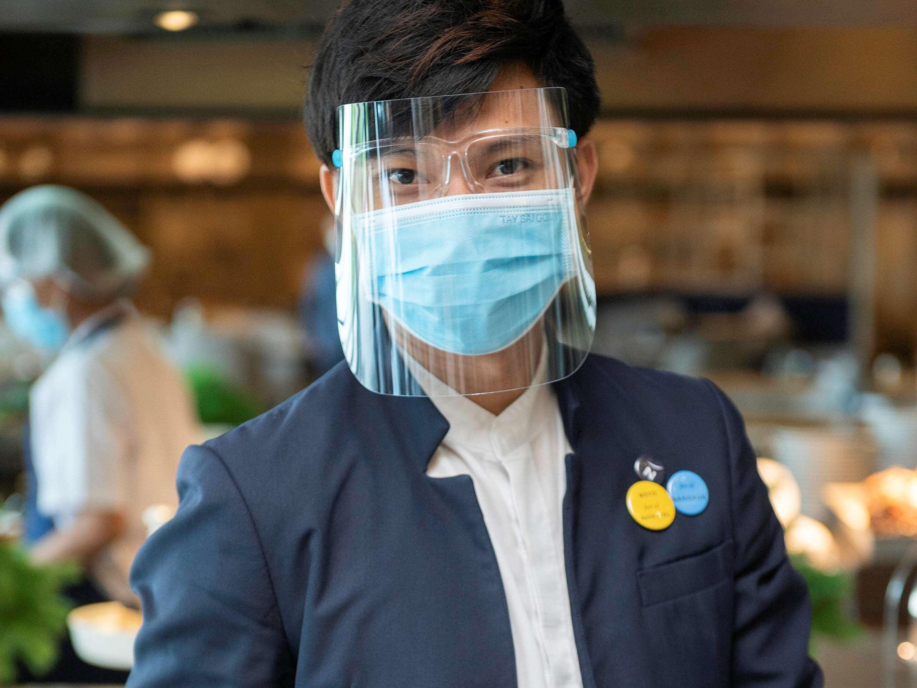Novotel Chennai Sipcot Exterior photo A Thai Airways employee wearing a face shield